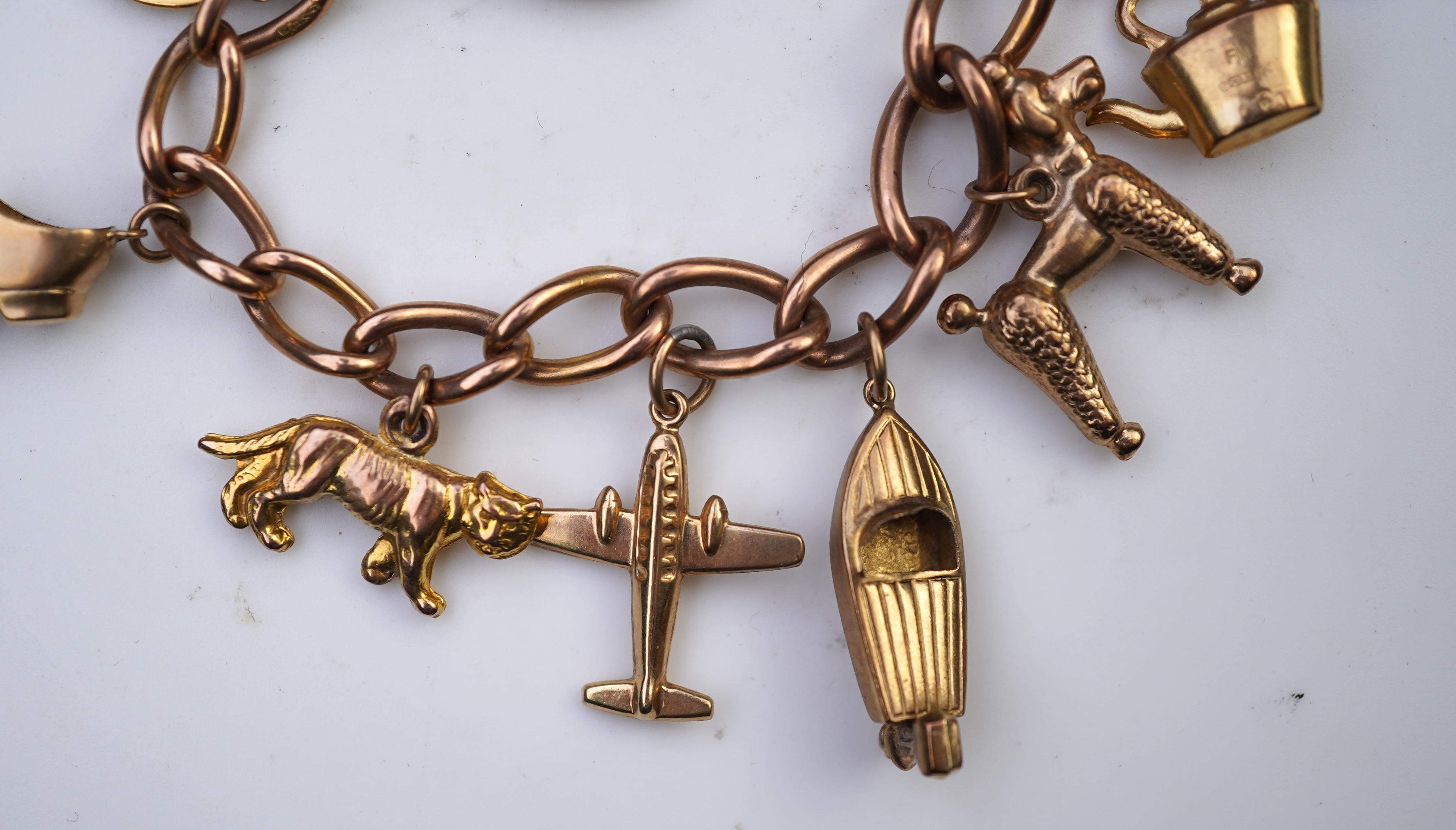 A gold charm bracelet, mid 20th century